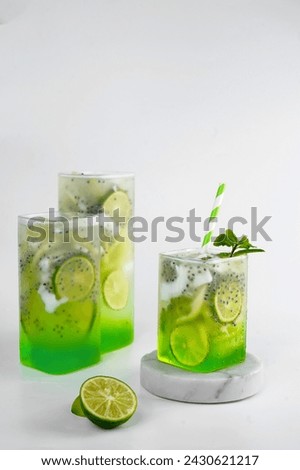 Three glasses of es kuwut or kuwut ice. Balinese fruit drink made from young coconut, seeds of selasih, lime and green syrup. Served for breakfasting in Ramadhan. Fresh drink Lebaran. Traditional  Royalty-Free Stock Photo #2430621217