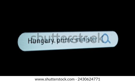 Shot of monitor screen. Pixel screen with animated search bar, keywords Hungary Prime Minister typed in, browser bar with magnifying glass and text headline.