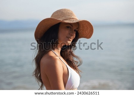 Smile, holiday and woman with hat at beach for travel adventure, thinking and relax in nature. Sunshine, summer and happy face of girl at ocean on vacation with water, reflection and resort in Bali.