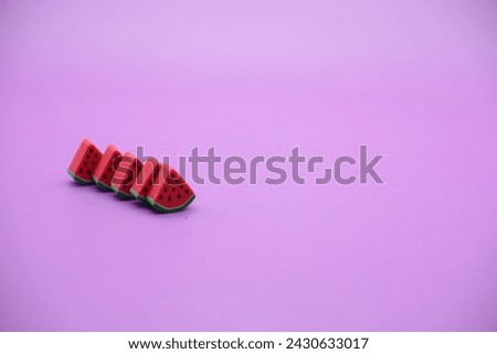 Mini watermelon toy isolated on purple background. purple background with watermelon toys.
