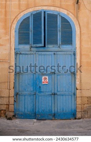 No parking sign on the blue wooden garage door