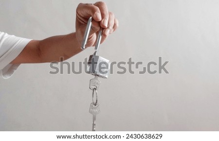 Iron padlock that is opened with a key on the bright background. A padlock in a man's hand. Concept of freedom. 