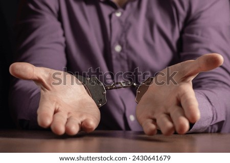 stressed out businessman hands bothered with handcuffs suffering at custody for concept of suspicious business, hostage or corporate justice, Royalty-Free Stock Photo #2430641679