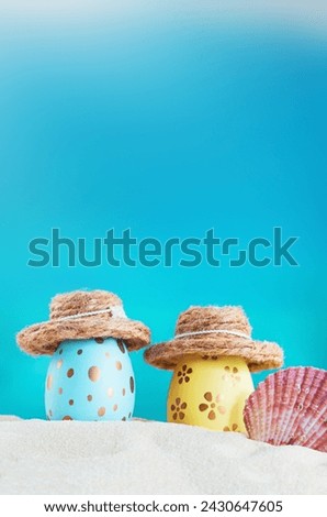 Yellow and blue eggs with polka dot in hat with conch on beach by sea on sunny day. Easter, travel, vacation. Vertical. Copy space Royalty-Free Stock Photo #2430647605