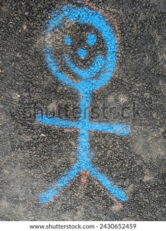 A Painted Smiley Stick Man Person On The Pavement Road