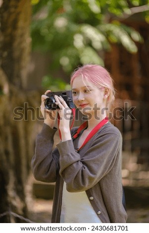 Beautiful woman with camera. Happy smiling woman taking photos of beautiful location. High Quality