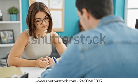 Two workers man and woman signing contract sitting on table at the office