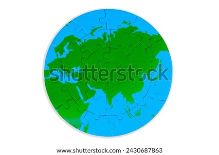 Circular puzzle map featuring rich green continents and serene blue oceans set against a white background. Unity, exploration, and environmental awareness related concept.