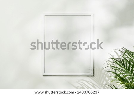 White wooden photo frame with plant leaves on white background