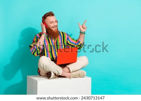 Full body length photo of it specialist loves working music headphones and laptop point finger copyspace isolated on blue color background