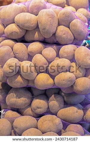 pre-packed varietal potatoes in nets in the supermarket Royalty-Free Stock Photo #2430714187