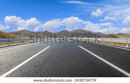 Straight asphalt highway road and mountain natural landscape under the blue sky