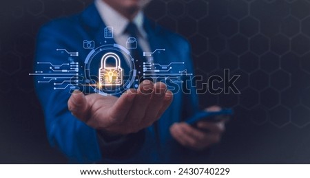 A businessman in a blue suit interacts with a futuristic holographic security interface, featuring a glowing padlock symbol, signifying advanced digital protection. Secure business networks Royalty-Free Stock Photo #2430740229