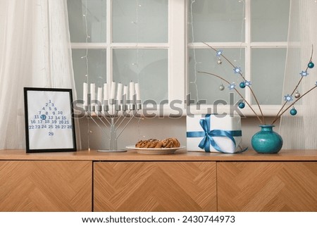 Wooden cabinet with traditional Hanukkah decorations at home, closeup Royalty-Free Stock Photo #2430744973