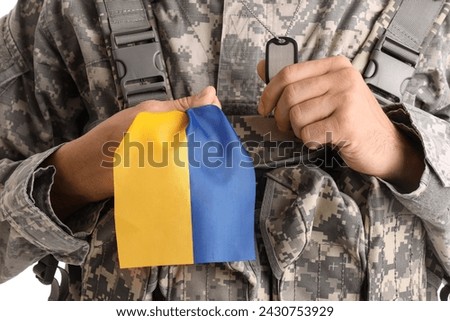 Male soldier with flag of Ukraine on white background