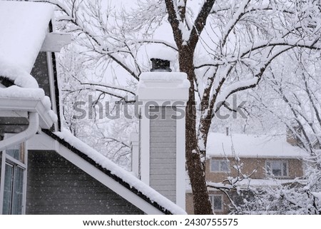 Roof chimney pipe and trees during winter snowfall weather moody landscape photo. Seasonal nature background texture.