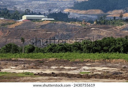View of opencast mining quarry with lots of machinery at work. Coal mines in East Kalimantan, Indonesia Royalty-Free Stock Photo #2430755619