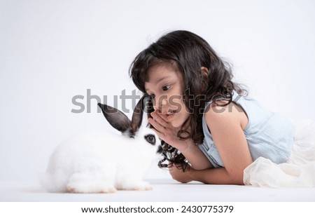 A little girl kisses her beloved fluffy rabbit, The beauty of friendship between humans and animals