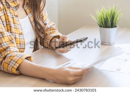 Bill pay concept. Online internet banking asian young woman hand hold invoice use mobile smart phone spend scan barcode to transfer to pay money of credit card without cash. Technology of financial Royalty-Free Stock Photo #2430783101