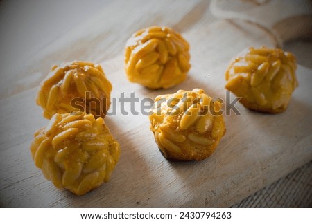 Pignoli cookies are Italian treats made with almond paste, sugar, and pine nuts. Their chewy interior and crispy exterior offer a delightful contrast, while the pine nuts add a nutty flavor. Royalty-Free Stock Photo #2430794263