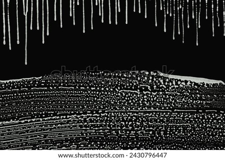 abstract soap lather dripping from clear glass, horizontal foam wipe marks, black background Royalty-Free Stock Photo #2430796447