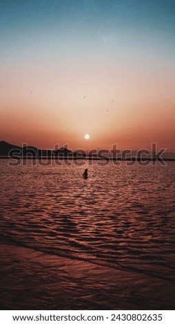 Las Canteras beach, photo of a woman in the middle of sunset Royalty-Free Stock Photo #2430802635