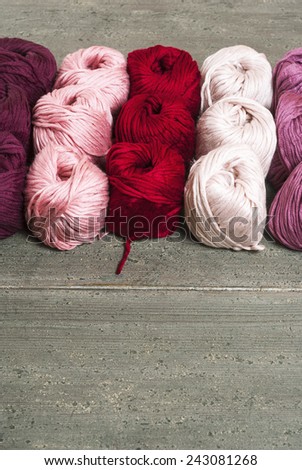 balls of wool in a row, rusty wood table background