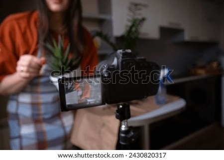 Girl filming blog on camera while replanting flowers Lifestyle blogger gardening at home. Trend content for social media and vlogs