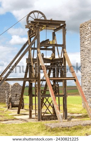 A pit head gear at the abandoned Magpie Lead Mine near the village of Sheldon in the Derbyshire Peak District, England. Royalty-Free Stock Photo #2430821225