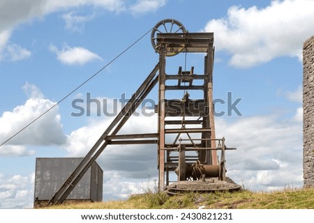 A pit head gear at the abandoned Magpie Lead Mine near the village of Sheldon in the Derbyshire Peak District, England. Royalty-Free Stock Photo #2430821231
