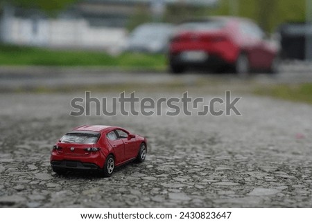 model mazda 3 car from HotWheels with a real japanese Mazda 3 car in red colour Royalty-Free Stock Photo #2430823647