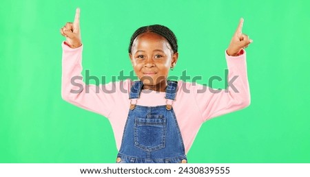 Children, pointing and a black girl on a green screen background in studio for marketing a product. Kids, portrait and advertising with a cute little female child showing space on chromakey mockup