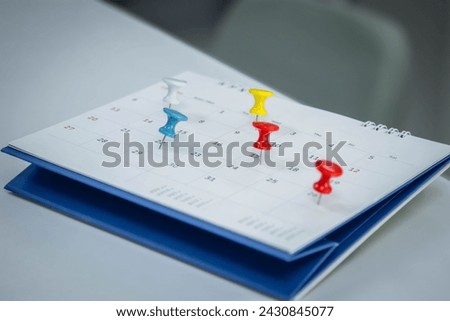 Mark on calendar white paper desk calendar with drawing-pins appointment and business meeting concept