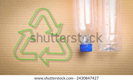Plastic empty bottles on cardboard background concept of recyclable materials and plastic recycling. Recycling, concept Eco, Recycle sign, reduce, reuse, recycle, recycle symbol.