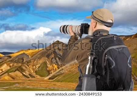 man tourist photographer with a backpack photographs the beauty of nature in the mountains. nature hikes in the mountains