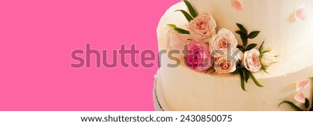 white wedding cake decorated with mastic flowers on a pink table. Picture for the menu or catalog of confectionery. wedding celebration concept