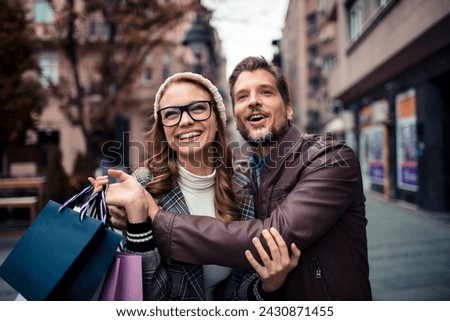 Attractive young couple with shopping bags in the city Royalty-Free Stock Photo #2430871455