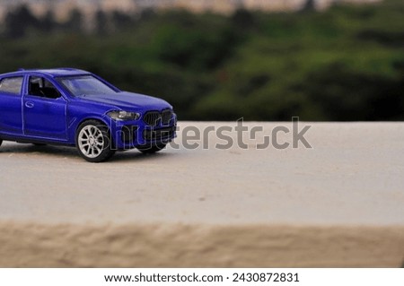 Toy car photography, violet color toy car with nature background
