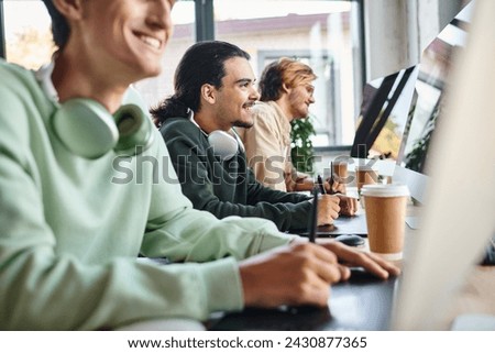 post production team smiling and editing photos in modern office space, cheerful men in 20s