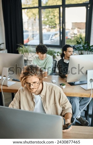 Focused man working on creative project and looking at monitor in office, post production team
