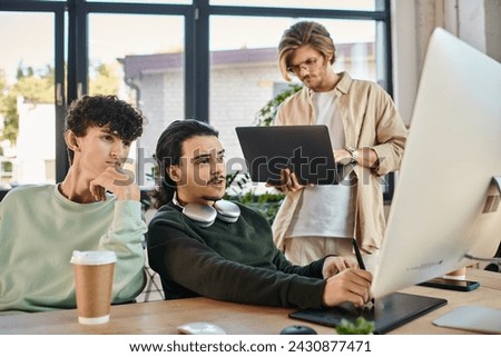 post-production team focused on a retouching project in office, man with laptop near coworkers