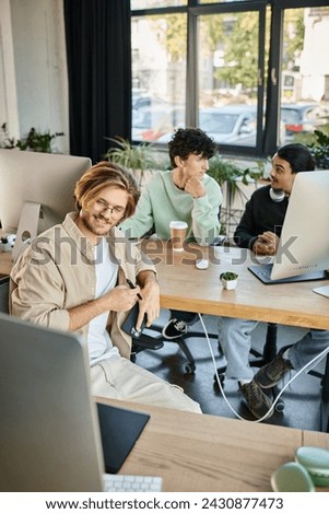 happy creative team intensely focused on post-production work in a modern office, men in 20s