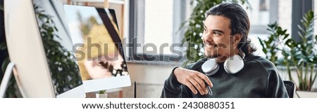 man with stylus pen and coffee smiling and looking at monitor in post-production office, banner