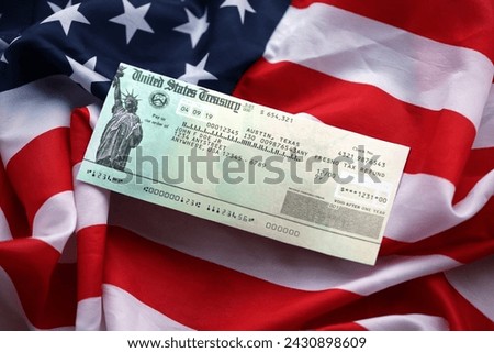 United States Treasury Refund check on waving American Flag close up. Royalty-Free Stock Photo #2430898609