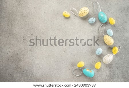 Easter frame of eggs and feathers on gray background. Happy Easter holiday concept.