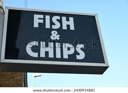 Fish and chips sign on blue sky background. Royalty-Free Stock Photo #2430914881