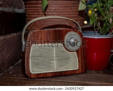 Antique radio on vintage background.  Retro portable broadcast radio receiver with wooden case design from circa 1955s