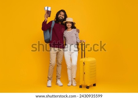 Hot traveling deal, cheap hotel or tickets. Beautiful young eastern man and woman tourists travelling together, carrying suitcase and backpack, showing passports, copy space, full length