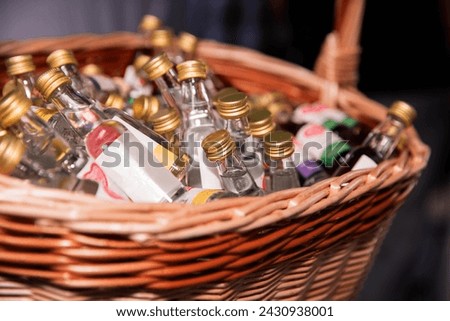 A variety of small liquor bottles displayed in a basket