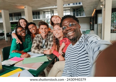 Happy young students taking a selfie portrait together at university library. African american guy shooting a photo with his smiley classmates on a high school meeting. Friends at academy. friendship